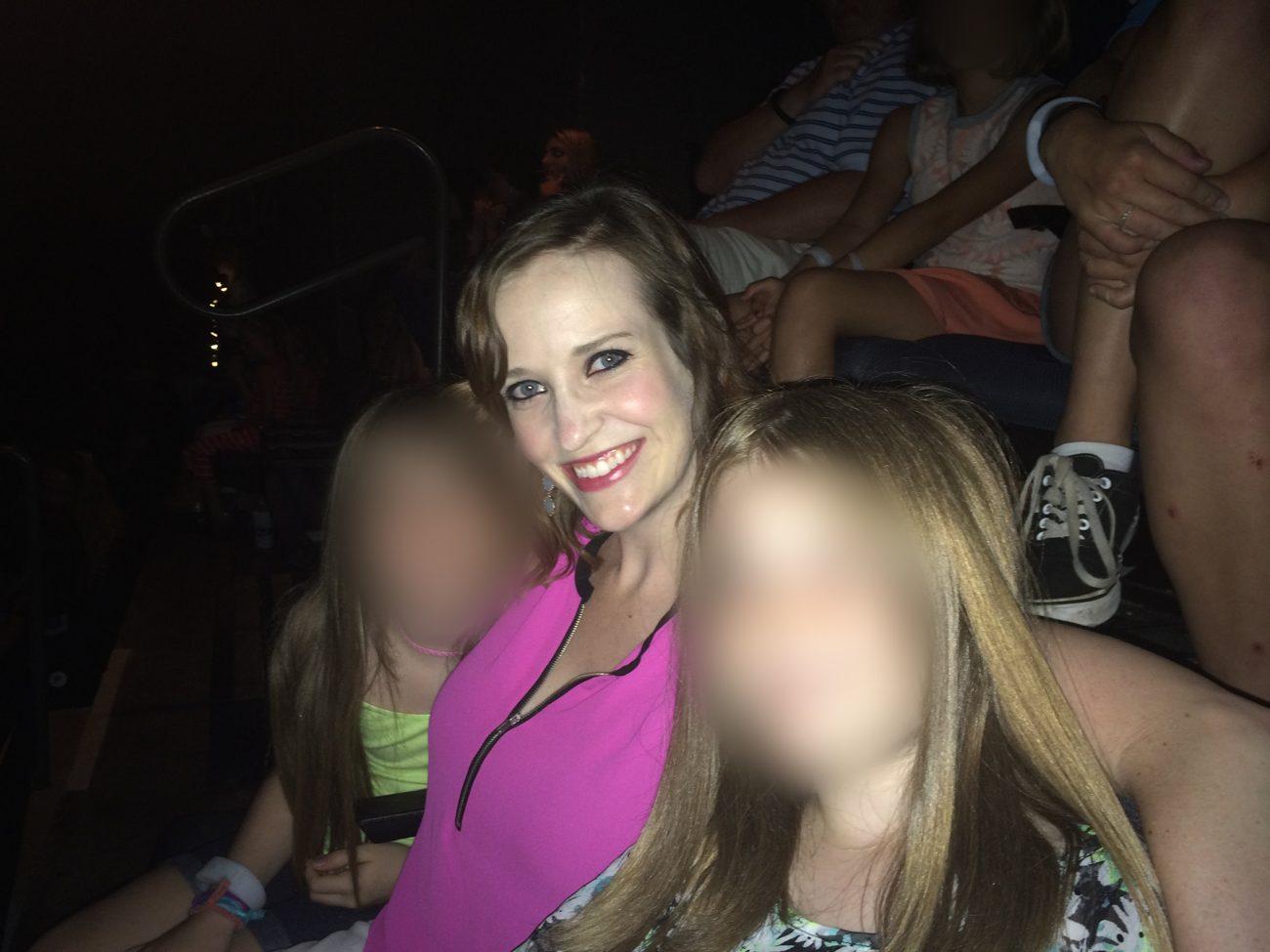 Ashley with her two stepdaughters at Taylor Swift’s 1989 World Tour in 2015, faces of the girls blurred