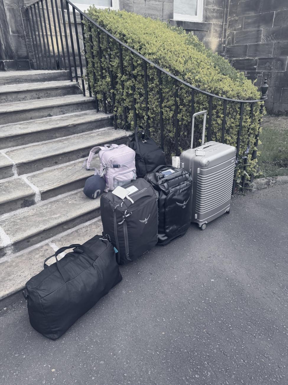 Luggage stacked on stone steps outside a building