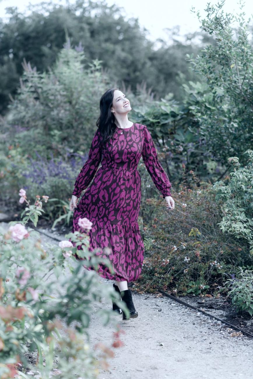 Ashley Thiesen walking a garden path, looking up