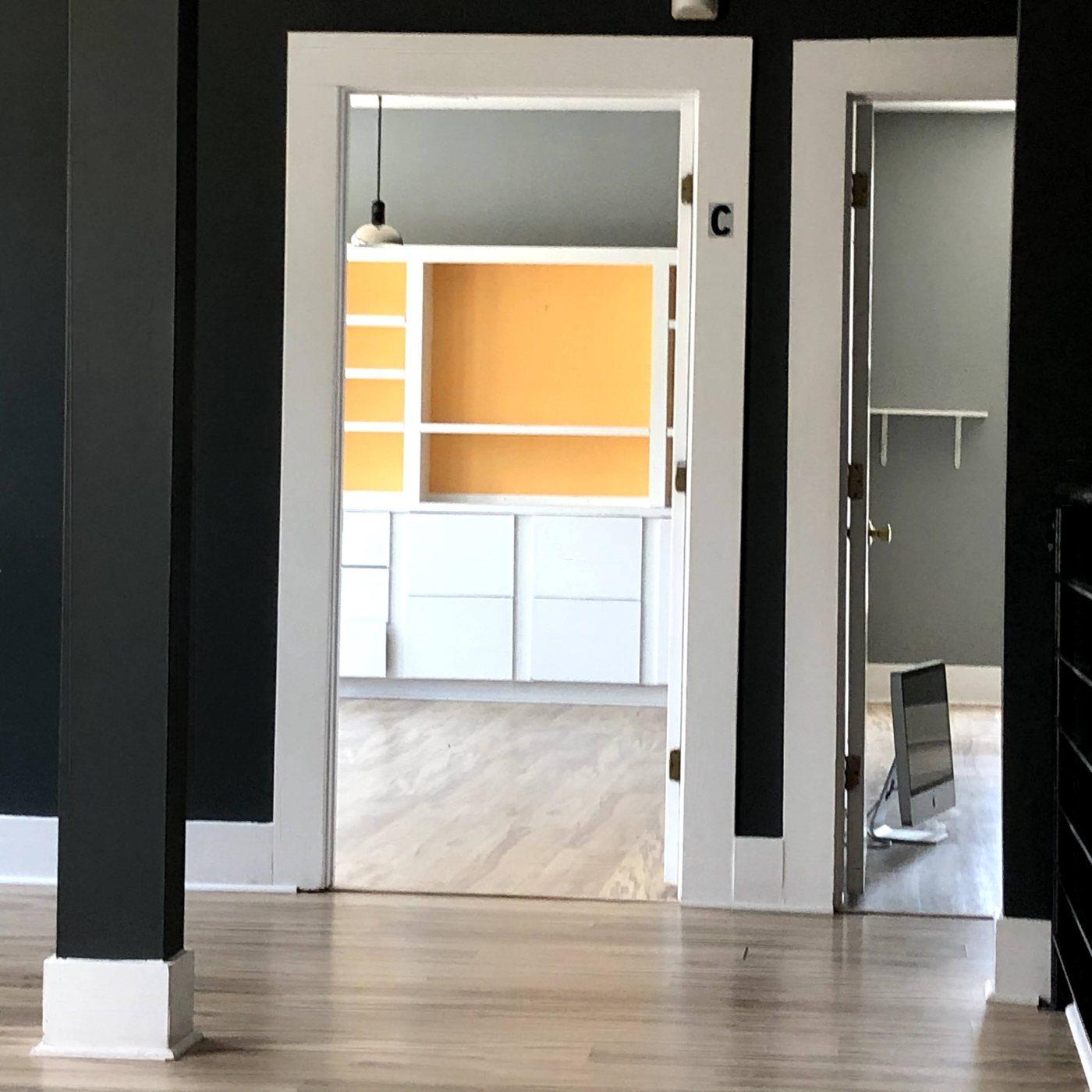 The empty offices of The Modern Connection in downtown Charleston, a doorway looking into a bare room with orange shelving