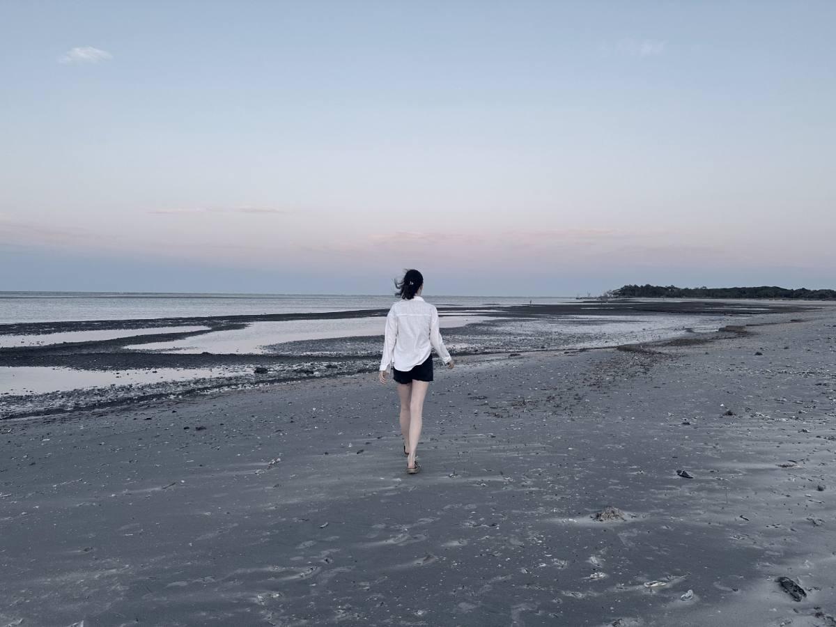Ashley walking a tidal flat at dusk