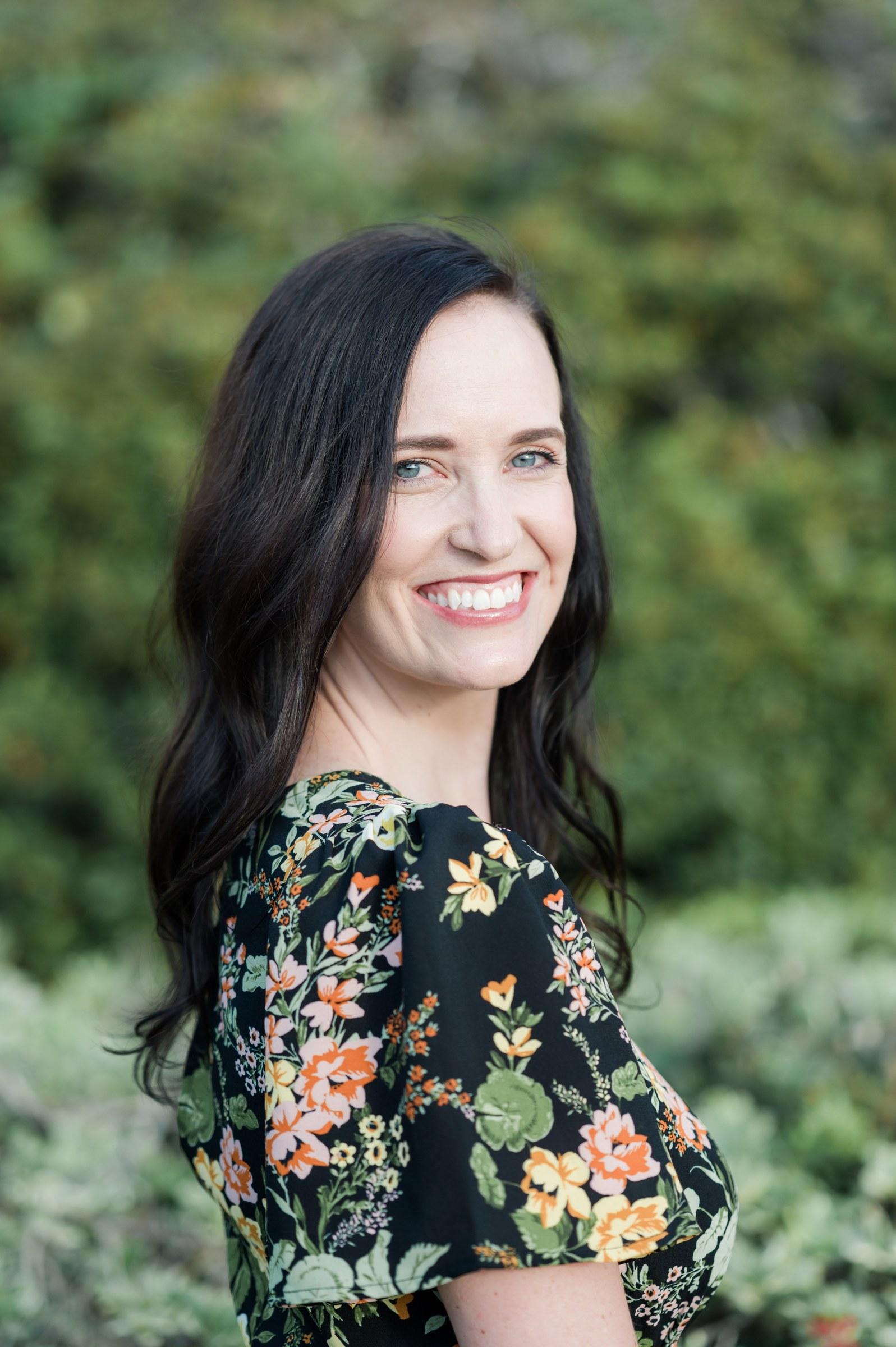 Ashley Thiesen smiling over her shoulder in a garden