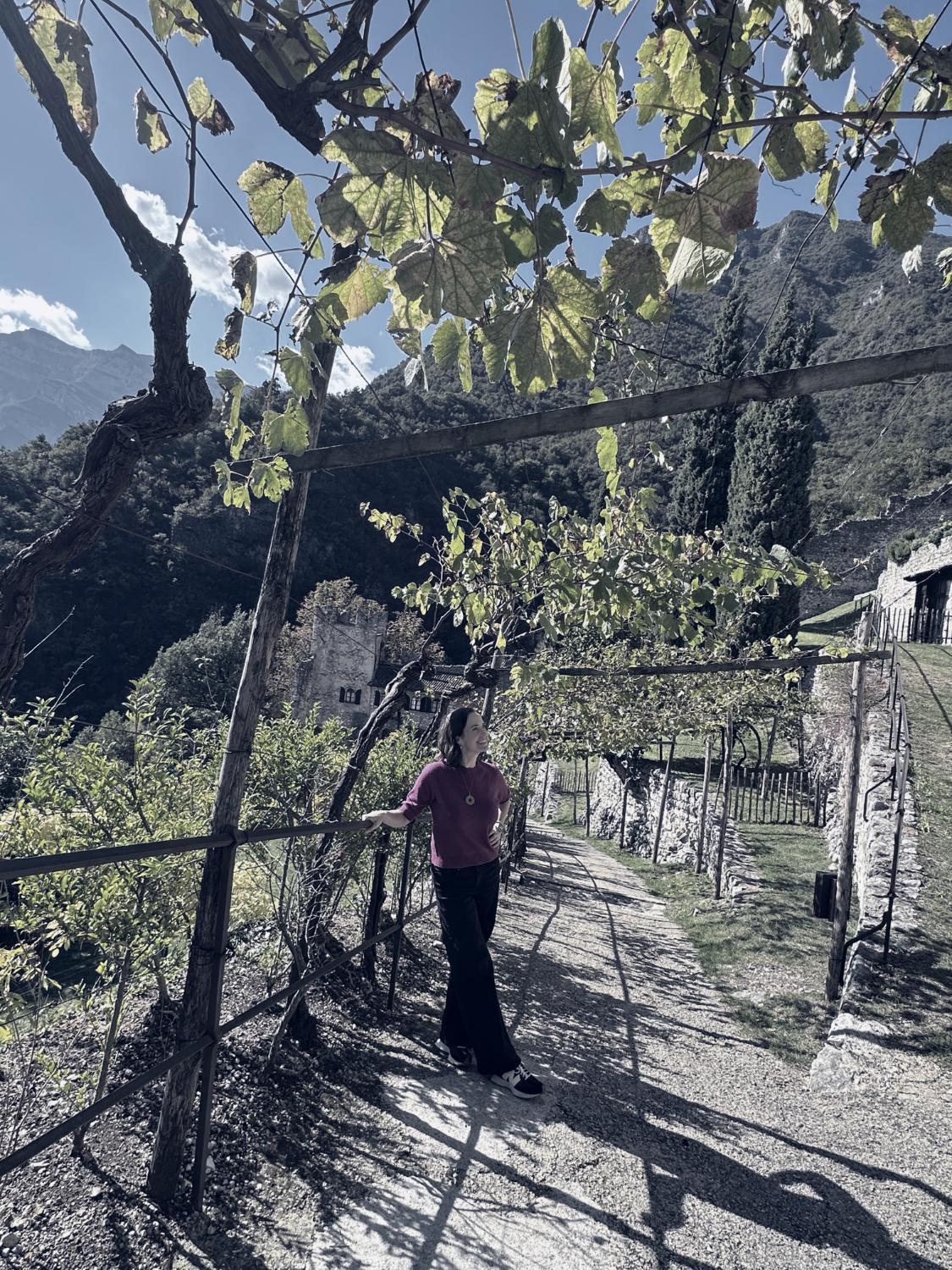 Ashley in a vineyard below a castle in the Italian Alps