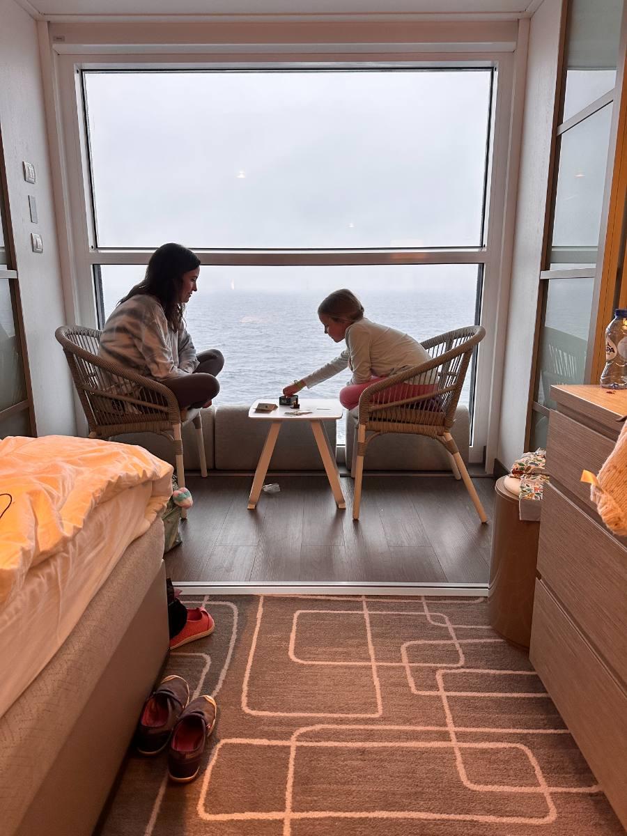 Ashley and her daughter playing a board game at a window over the sea