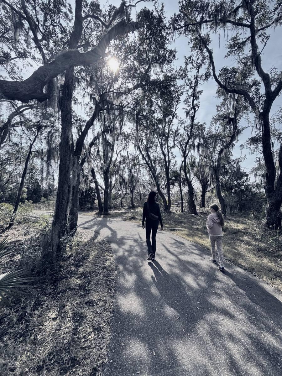 Ashley and her daughter walking a path under Charleston live oaks