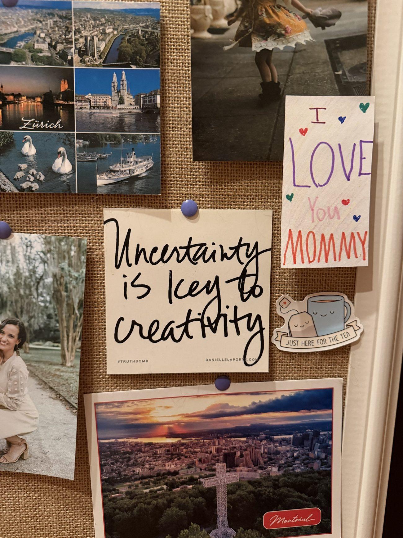 Ashley’s office corkboard: a Danielle LaPorte #truthbomb card that reads “Uncertainty is key to creativity,” pinned between travel postcards from Zürich and Montréal, a child’s “I love you Mommy” note and a tea sticker