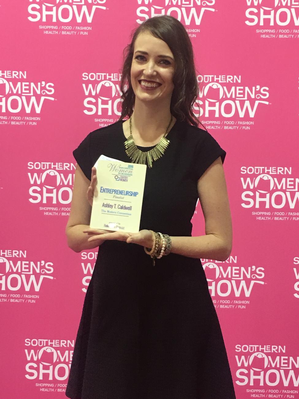 Ashley Caldwell holding her Influential Women in Business finalist award from the Center for Women at the 2016 Southern Women's Show in Charleston