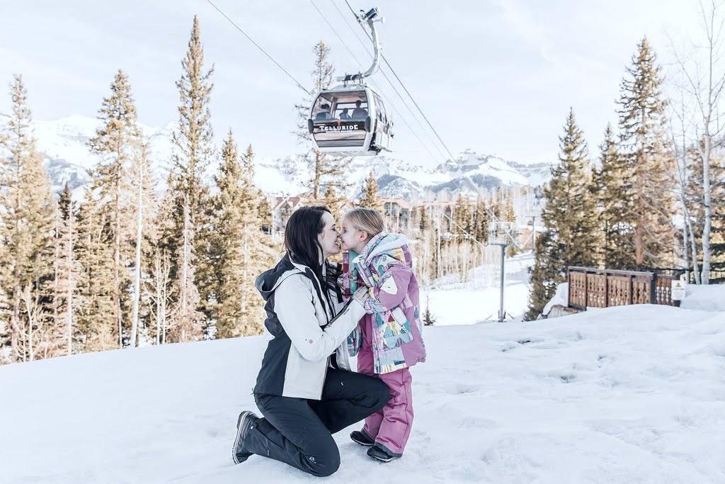 Ashley and her daughter nose to nose in the snow in Telluride