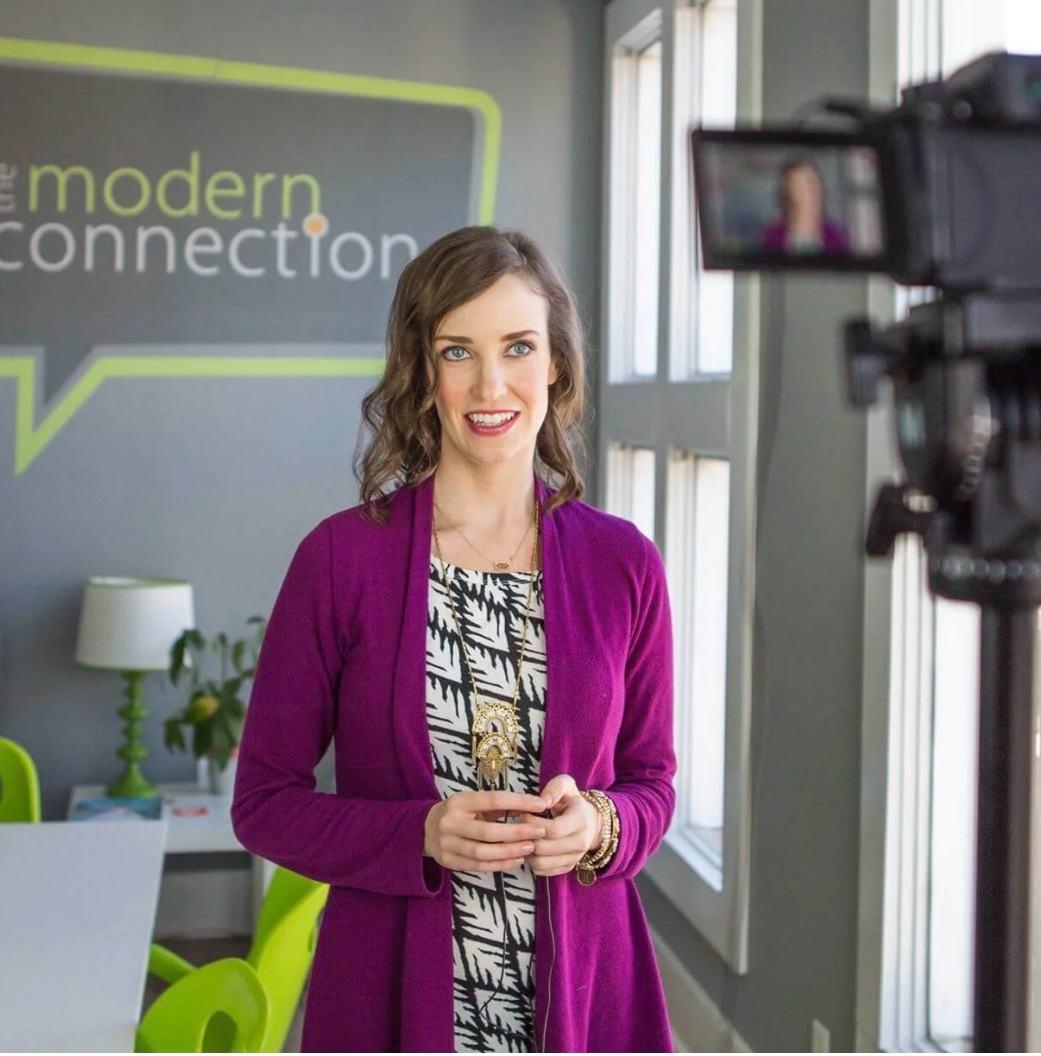 Ashley Thiesen being filmed at The Modern Connection in Charleston, company signage behind her